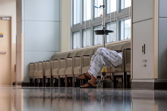 A patient is sitting on a chair at a hospital in Seoul on Sunday. (Yonhap)