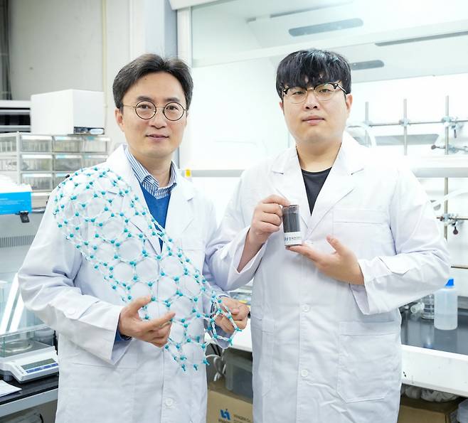 한중탁(왼쪽) 박사와 이도근 학생연구원이 질소도핑 단일벽 탄소나노튜브 모형과 복합음극재를 들어 보이고 있다. [KERI 제공]