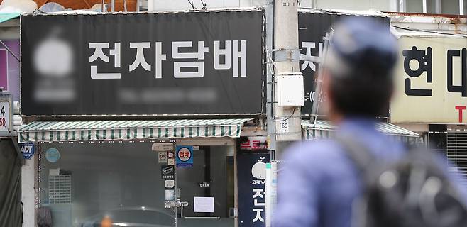서울시내의 한 전자담배 판매점 앞으로 시민들이 지나가고 있다. /뉴스1