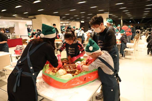 GS건설 임직원과 가족들이 지난해 11월 25일 서울 종로구 GS건설 본사 사원식당에서 열린 '김치 투게더' 행사에서 김장을 담그고 있다. GS건설 제공