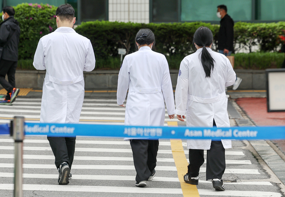 Doctors are seen near the hospital in Seoul on Wednesday amid the prolonged walkout of trainee doctors in protest of government's plan to increase medical school admission seats. [NEWS1]