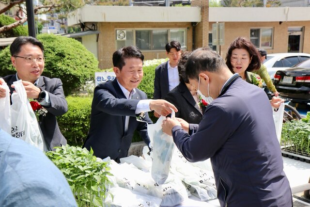 23일 열린 대전시 화요직거래장터 개장식에서 김영훈 대전농협본부장(왼쪽 두번째)이 장터를 찾은 주민에게 고추 모종을 나눠주고 있다.