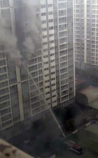 25일 오후 부산 남구 용호동의 한 아파트에 화재가 발생해 소방차가 물을 쏘고 있다(사진=연합뉴스)