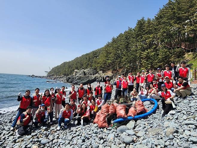 지난 19일 부산 해운대 해안정화활동에 참여한 롯데호텔앤리조트 임직원과 관계자들이 기념사진을 촬영하고 있다.