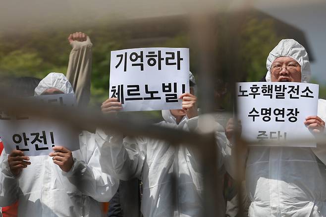 방진복을 입은 탈핵시민행동 활동가들이 손팻말을 들고 구호를 외치고 있다. 김혜윤 기자