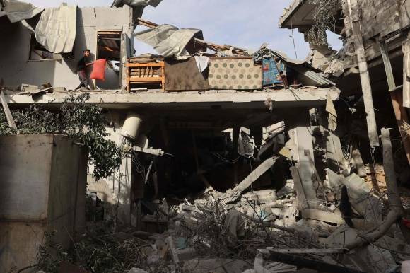 이스라엘과 팔레스타인 무장정파 하마스 간의 분쟁이 계속되는 가운데 25일(현지시간) 가자지구 최남단 이집트 접경도시 라파에서 한 팔레스타인 청년이 밤새 이스라엘의 폭격으로 무너진 건물 잔해에서 실종자를 수색하고 있다. 라파 AFP 연합뉴스