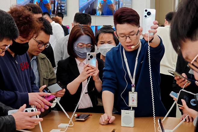 중국 상하이의 한 스마트폰 매장에서 사람들이 화웨이의 최신 스마트폰 ‘퓨라70’ 시리즈를 살펴보고 있다.(사진=AFP)