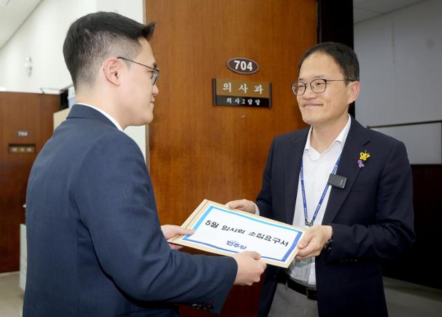 박주민(오른쪽) 더불어민주당 원내수석부대표가 26일 국회 의사과에 5월 임시회 소집요구서를 제출하고 있다. 뉴스1