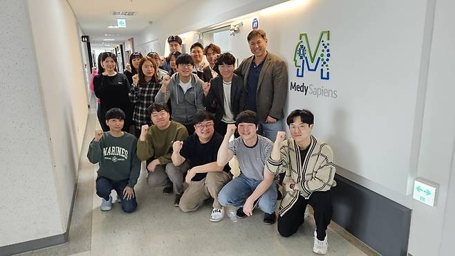 강상구 메디사피엔스 대표(뒷줄 맨 오른쪽)와 직원들이 희귀질환 진단 기업으로서의 사명을 강조하며 화이팅을 외치고 있다. [사진제공=메디사피엔스]
