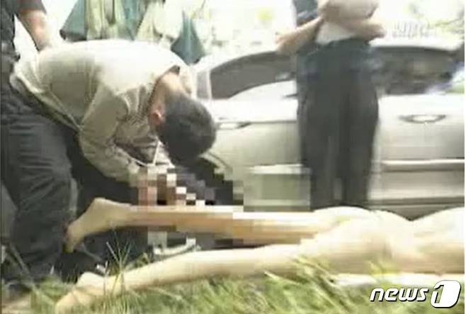 2002년 5월 허재필이 현장검증에서 첫 범행 대상인 A 씨 시신을 야산에 파묻는 장면을 재현하고 있다. (MBC 갈무리) ⓒ 뉴스1