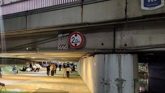 서울 관악구 봉림교 아래 도림천 수변 공원에서 버스킹 공연하는 '다리 밑 프로젝트' 옆으로 시민들이 걸어가고 있다. 김서원 기자