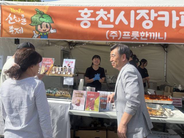 ▲ 강원n홍천 산나물 축제가 26~28일간 홍천 토리숲에서 열리는 가운데 오흥수 홍천부군수가 부스를 돌며 관계자들을 격려하고 있다.