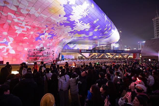 A crowd watches a media display projected onto the Dongdaemun Design Plaza during a New Year's Eve countdown event on Dec. 31, 2023. (Seoul Design Foundation)