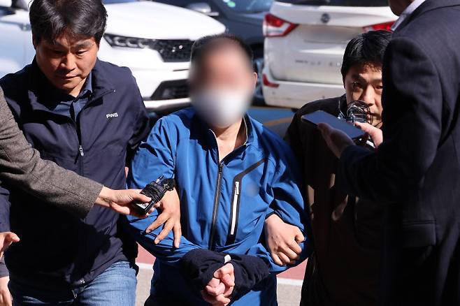 대법원 민원실에 전화해 “대법관을 죽이겠다”고 협박한 혐의로 긴급 체포된 50대 남성이 지난 25일 오후 서울 서초경찰서로 압송되고 있다. (사진=연합뉴스)