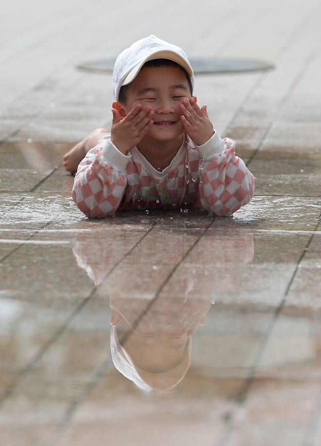 조연호(3)군이 서울광장 분수대에서 나온 물로 세수하고 있다. 김영원 기자