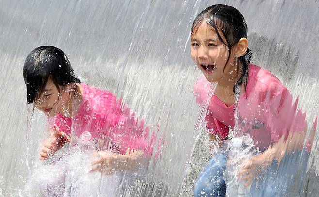 28일 오후 경기도 고양시 호수공원 계단바닥분수에서 아이들이 물놀이를 하며 더위를 식히고 있다. 뉴스1