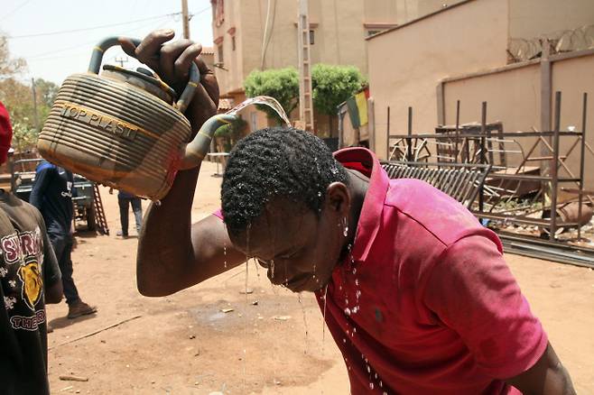 아프리카 말리 수도 바마코 시민이 지난 18일(현지시간) 더위를 식히기 위해 주전자의 물을 머리에 붓고 있다. 이날 바마코 평균기온은 44도를 기록했다. AP연합뉴스