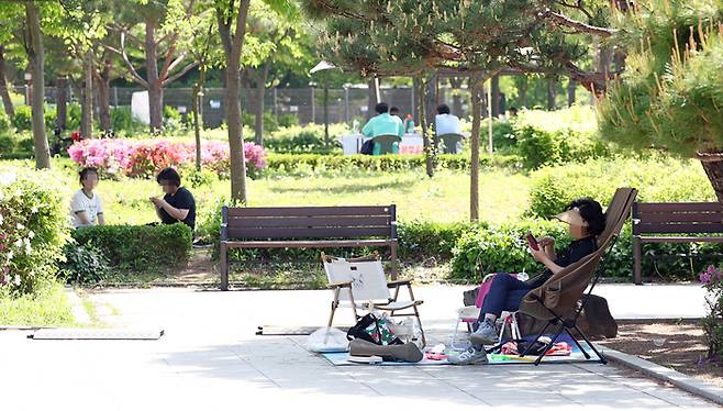 지난 27일 서울 관악구 낙성대공원에서 시민들이 그늘에 앉아 휴식을 취하고 있다. [사진 = 연합뉴스]
