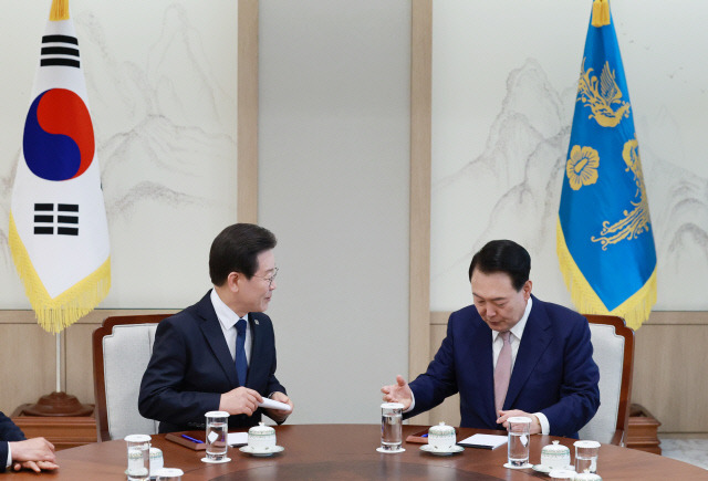 이재명 민주당 대표가 29일 서울 용산 대통령실 집무실에서 열린 윤석열 대통령과의 영수회담에서 미리 준비해 온 메시지를 품에서 꺼낸 뒤 윤 대통령과 대화하고 있다. 연합뉴스