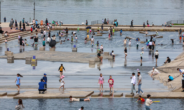 서울 한낮 기온이 28도까지 오르며 초여름 날씨를 보인 28일 오후 서울 영등포구 여의도한강공원 물빛광장에서 시민들이 물놀이를 즐기고 있다. 연합뉴스