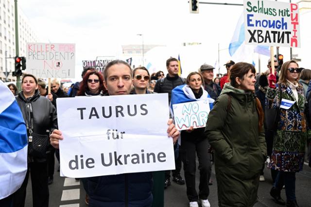 지난달 17일 독일 베를린에서 열린 블라디미르 푸틴 러시아 대통령 반대 시위에서 한 참석자가 "우크라이나를 위한 타우러스"라는 플래카드를 들고 있다. 베를린=로이터 연합뉴스