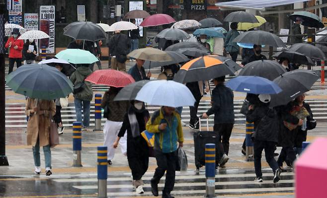 29일 부산 동구 부산역 앞 횡단보도에서 시민들이 우산을 쓴 채 이동하고 있다. 송봉근 기자