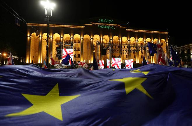 28일(현지시간) 조지아 수도 트빌리시 의사당 건물 앞에서 열린 시위에서 참가자들이 대형 유럽연합(EU) 깃발을 펼쳐들고 있다. 로이터연합뉴스