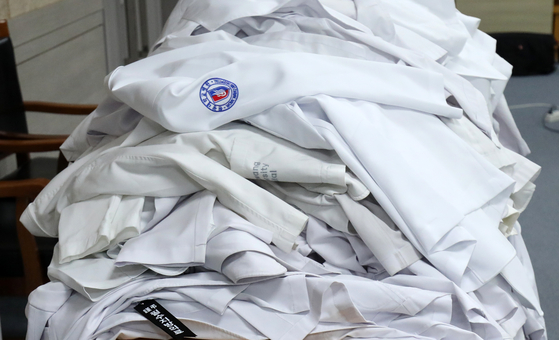 Doctors' gowns are piled on a desk as medical professors of Wonkwang University Hospital in North Jeolla return their gowns following their resignation submissions on Monday. [NEWS1]