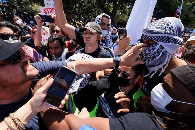 가자지구 전쟁을 두고 각각 이스라엘과 팔레스타인을 지지하는 시위대가 28일(현지시간) 미국 로스앤젤레스 캘리포니아대(UCLA) 캠퍼스에서 실랑이를 벌이고 있다. 미국 전역 50여 개 대학에서 천막 농성과 시위가 진행되면서 일부 격한 충돌 사례가 발생하고 있다.  연합뉴스