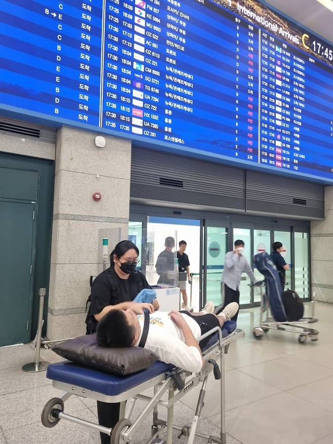 해외 근무중 쓰러진 백 모씨가 25일 환자이송침대에 실려 인천국제공항 입국장으로 들어오고 있다. / 사진제공=성남시
