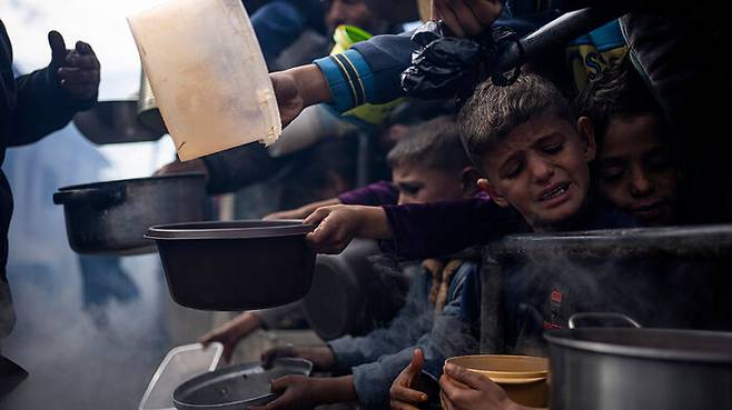 가자지구 라파에서 식사를 위해 줄을 서고 있는 팔레스타인인들