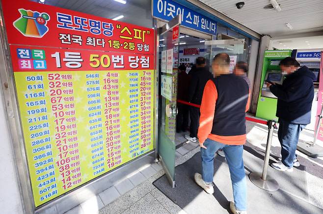 지난달 8일 서울 한 복권판매점에서 고객들이 줄지어 복권 구입을 기다리고 있다.(사진 = 뉴시스)