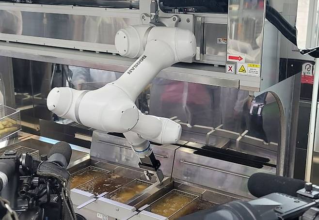 두산로보틱스 협동로봇이 단체급식 튀김작업을 수행하고 있다. ⓒ두산로보틱스
