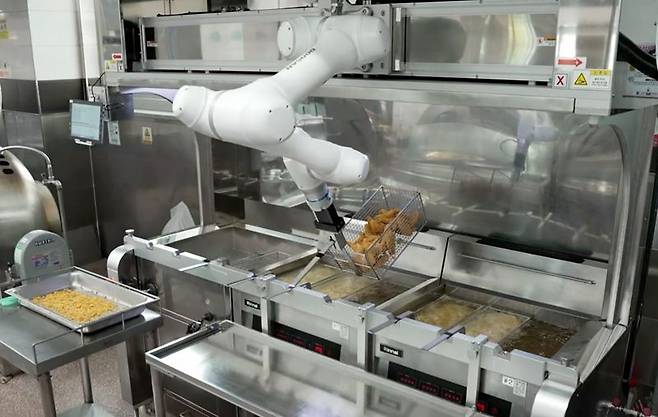 두산로보틱스 협동로봇이 단체급식 튀김작업을 수행하는 모습. 두산로보틱스 제공
