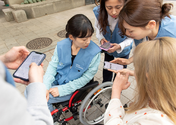 포스코인터내셔널 임직원들이 직접 휠체어를 타고 휠비(휠체어 전용 네비게이션) 앱에 들어갈 위치 정보를 수집하고 있다. [사진=포스코인터내셔널]