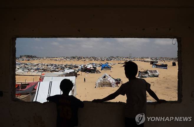 가자지구 최남단 라파의 피란민 캠프에서 주변을 바라보는 팔레스타인 어린이들 [AFP 연합뉴스자료사진. 재판매 및 DB 금지]