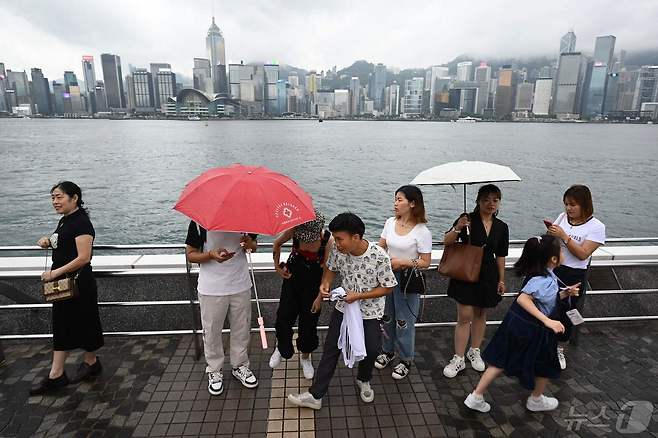 1일(현지시간)  황금 연휴기간 홍콩 침사추이를 방문한 중국       관광객들이 우산을 들고 있다. 2024.05.01 ⓒ AFP=뉴스1 ⓒ News1 정지윤 기자
