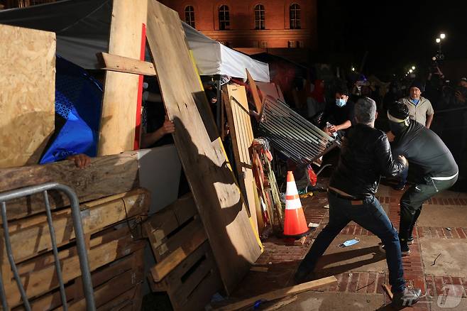 미국 캘리포니아주 로스앤젤레스에서 친이스라엘 시위대가 로스앤젤레스 캘리포니아 대학교(UCLA) 캠퍼스 내 친팔레스타인 시위대의 바리케이드를 공격하고 있다. ⓒ 로이터=뉴스1 ⓒ News1 김현 특파원