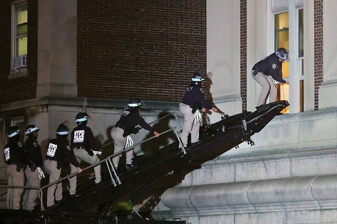 30일 밤 미국 뉴욕 경찰이 가자지구 전쟁에 반대하는 학생들이 점거하고 있는 뉴욕 컬럼비아대의 해밀턴홀에 사다리차를 이용해 진입하고 있다. 뉴욕/AFP 연합뉴스