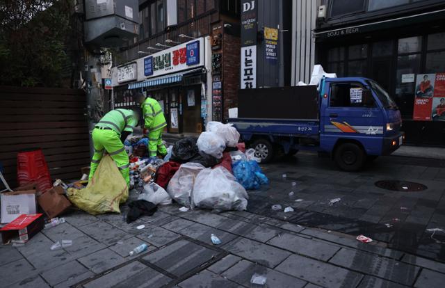 서울 용산구에서 환경미화원들이 이른 아침부터 거리에 쌓인 쓰레기를 치우고 있다. 연합뉴스