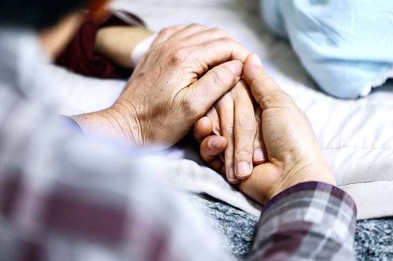 한 말기암 환자의 손을 남편이 잡아주고 있다. 김종호 기자
