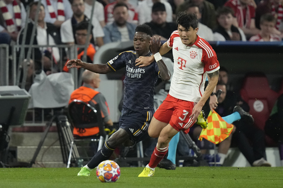 Real Madrid's Vinicius Junior, left, fights for the ball with Bayern's Kim Min-jae during the Champions League semifinal first leg match between Bayern Munich and Real Madrid at the Allianz Arena in Munich, Germany on Tuesday. [AP/YONHAP]