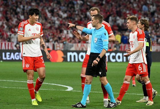 Bayern Munich's Kim Min-jae, left, remonstrates with referee Clement Turpin after a penalty is awarded to Real Madrid at Allianz Arena in Madrid, Germany on Tuesday. [REUTERS/YONHAP]