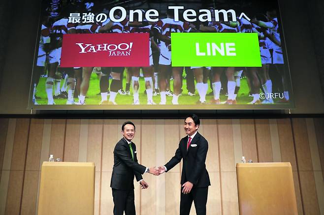 2019년 11월 야후재팬을 운영하는 Z홀딩스 최고경영자(CEO) 가와베 겐타로(왼쪽)와 이데자와 다케시 라인 CEO가 손을 잡으며 경영 통합을 선언하고 있다. 당시 네이버와 소프트뱅크는 일본 국민 메신저 ‘라인’과 일본 최대 검색 서비스 ‘야후재팬’의 통합으로 구글·아마존 등 글로벌 IT 기업들을 넘어서겠다는 목표를 제시했었다./게티이미지코리아
