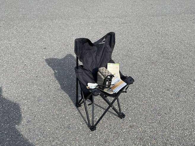 사람 대신 말하는 기계가 앉아 있는 캠핑의자. 사진 전치형