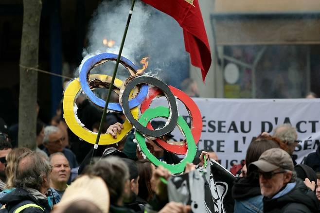 1일(현지시간) 파리에서 열린 노동절 집회에서 시민들이 골판지로 만든 올림픽 오륜기 모형을 태우고 있다. AFP연합뉴스