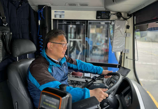 경기 광명 공영차고지에서 23년 차 버스 기사 김진후(53)씨가 버스 운행을 시작하기 위해 운전대 앞에 앉은 모습.