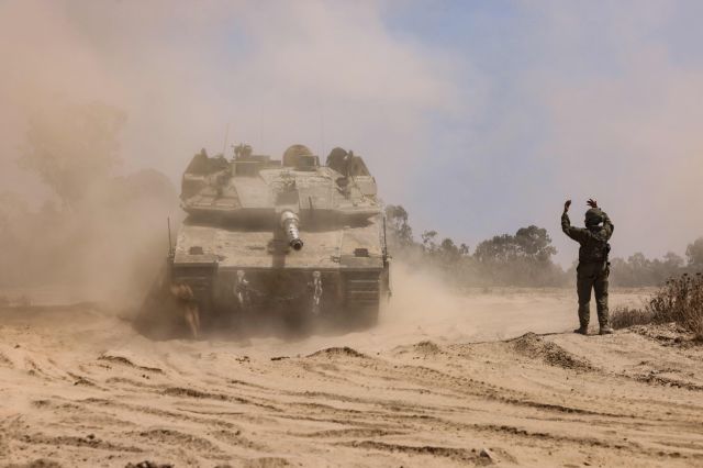 이스라엘 군인이 2일(현지시간) 가자지구 접경에서 이동하는 전차에 수신호를 보내고 있다. AFP연합뉴스