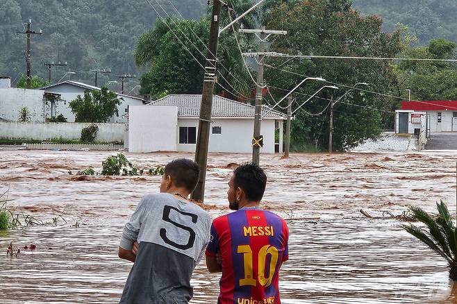 1일(현지시간) 브라질 히우그란지두술주 엔칸타도에서 폭우로 물에 잠긴 거리를 사람들이 바라보고 있다.브라질 당국은 폭우로 이 지역에서 최소 10명이 숨지고 21명이 실종됐다고 밝혔다. 2024.05.01 ⓒ AFP=뉴스1 ⓒ News1 정지윤 기자