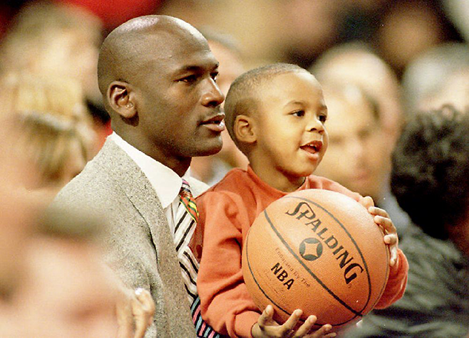 마이클 조던이 1993년 11월 시카고 불스 홈구장에서 아들 마커스를 안고 마이애미 히트와 경기를 보고 있다. 당시 조던은 NBA 3연패 달성 후 농구선수 은퇴를 선언한 상태였다. 사진=AFP=연합뉴스 제공